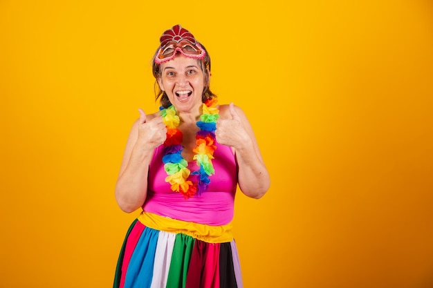 Femme adulte en vêtements de carnaval souriant à la caméra doigt pouce levé