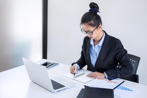 Une femme d'affaires adulte travaillant sur un ordinateur portable sur un bureau.