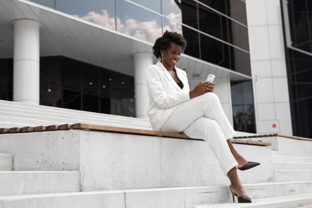 Une femme d'affaires africaine prospère avec un téléphone portable