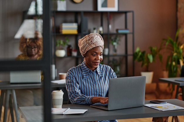 Femme d'affaires africaine travaillant au bureau