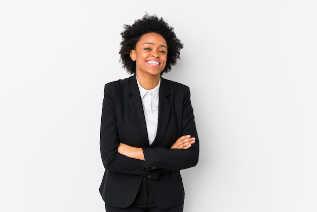 Femme d'affaires afro-américaine d'âge moyen contre un mur blanc en riant et en s'amusant.