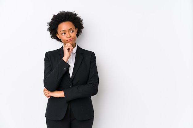 Femme d'affaires afro-américaine d'âge moyen à la recherche de côté avec une expression douteuse et sceptique.