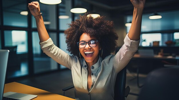 Une femme d'affaires afro-américaine excitée sur le lieu de travail célébrant l'affaire réussie.