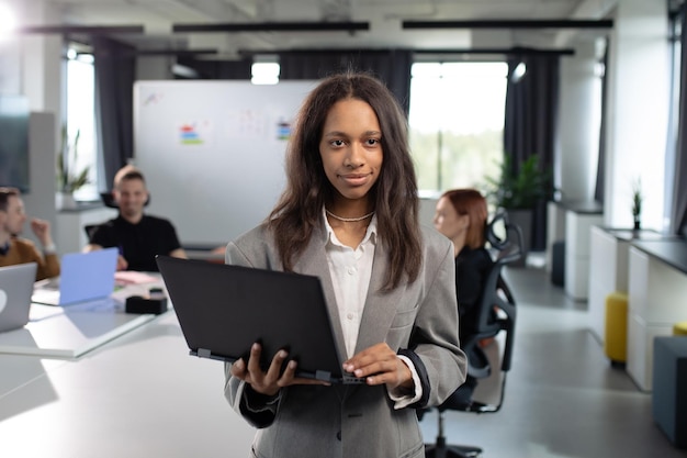 Femme d'affaires afro-américaine avec un ordinateur portable au bureau