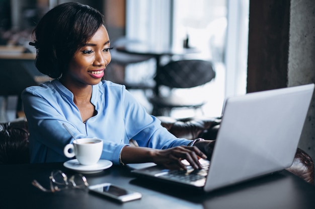 Femme d&#39;affaires afro-américaine avec ordinateur portable dans un café