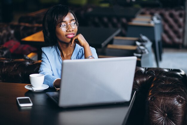 Femme d&#39;affaires afro-américaine avec ordinateur portable dans un café