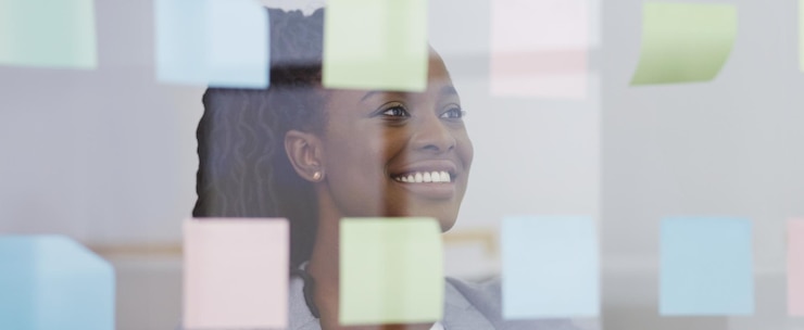 Photo une femme d'affaires afro-américaine réfléchit avec des notes collantes colorées sur la planification du mur de verre et