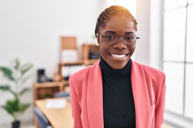 Femme d'affaires afro-américaine souriante confiante debout au bureau