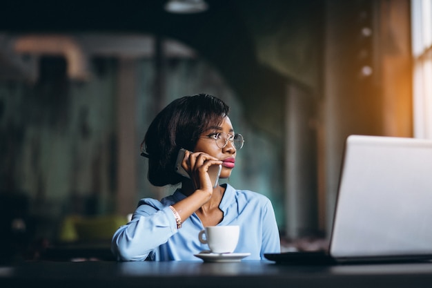 Femme d&#39;affaires afro-américaine avec téléphone et ordinateur portable