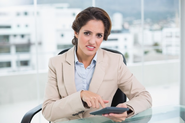 Femme d&#39;affaires agacé à l&#39;aide de la calculatrice