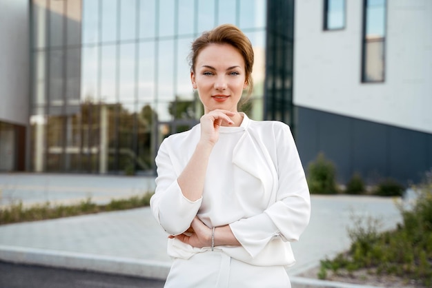 Femme d'affaires d'âge moyen confiante regardant la caméra debout dans la rue. Entreprise prospère