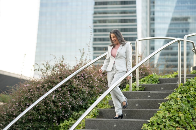 Femme d'affaires d'âge moyen descendant les escaliers