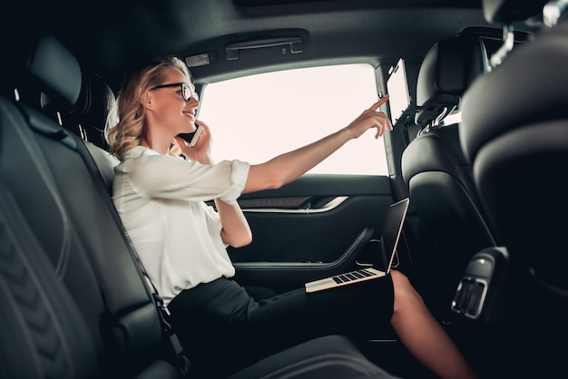 Femme d'affaires à l'aide d'un panneau d'ordinateur dans la voiture