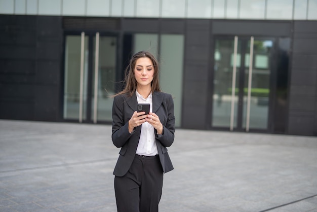 Femme d'affaires à l'aide d'un smartphone en plein air