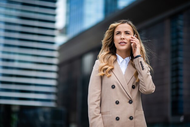 Femme d'affaires à l'aide de son téléphone portable en plein air