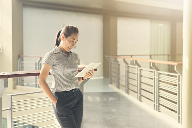 Femme d&#39;affaires à l&#39;aide de tablette au bureau.