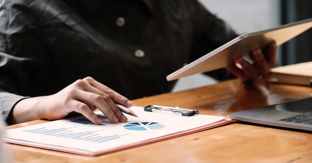 Femme d'affaires à l'aide d'une tablette pour l'analyse du rapport financier