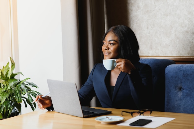 femme d'affaires américaine africaine à l'aide d'ordinateur au bureau