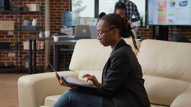 Femme d'affaires analysant les statistiques de données sur l'écran d'un ordinateur portable, utilisant la présentation financière et l'examen des ventes marketing dans le bureau de démarrage. Ouvrière planifiant le développement du travail sur le réseau.