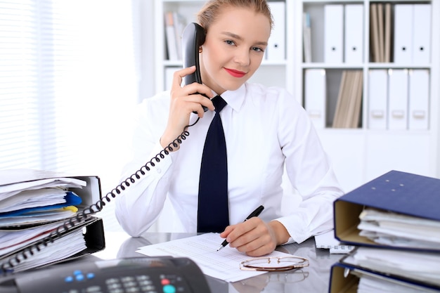 Photo une femme d'affaires appelle par téléphone pour faire un rapport, calculer ou vérifier le solde