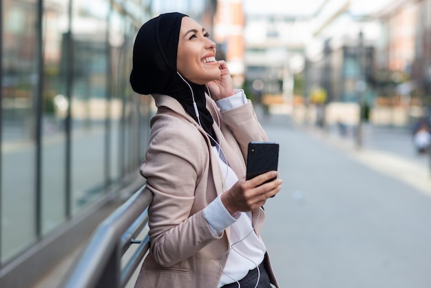 Femme d'affaires arabe écoutant de la musique à l'extérieur2