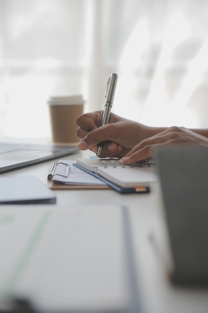 Femme d'affaires asiatique à l'aide d'un ordinateur portable et travaillant au bureau avec un document de calculatrice sur le bureau faisant la planification analysant le rapport financier plan d'affaires concept d'analyse financière d'investissement