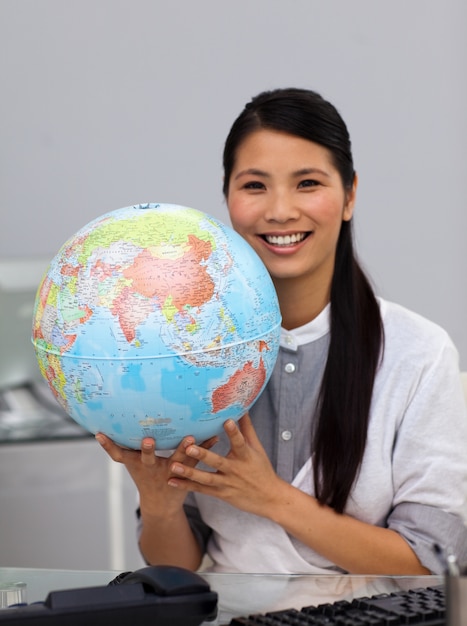 Femme d&#39;affaires asiatique assertive tenant un globe