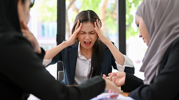 Femme d'affaires asiatique en colère et folle lors de la réunion avec son équipe non professionnelle