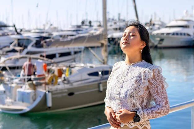 Femme d'affaires asiatique détendue en hiver respirant de l'air frais à l'extérieur au port maritime