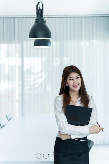 Femme d'affaires asiatique avec document et stylo au bureau