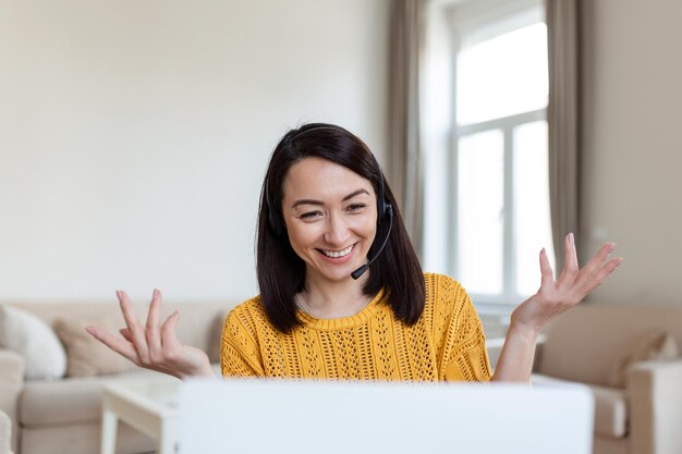 Femme d'affaires asiatique enseignant tuteur porter un casque sans fil visioconférence appelant sur un ordinateur portable parler par webcam apprendre enseigner dans le chat en ligne webinaire à distance concept d'enseignement en ligne