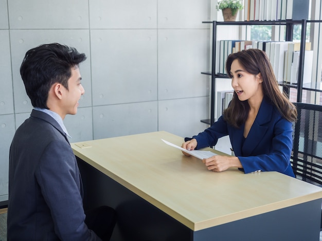 Femme d'affaires asiatique, examen des ressources humaines CV de jeune homme d'affaires asiatique en costume au bureau