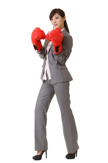 Femme d'affaires asiatique avec des gants de boxe rouges