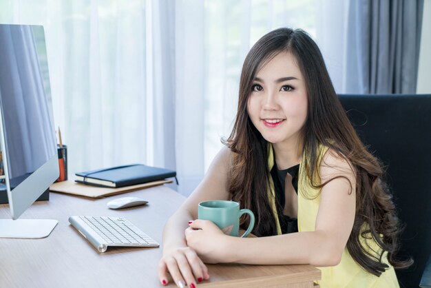 femme d&#39;affaires asiatique heureuse avec une tasse de café