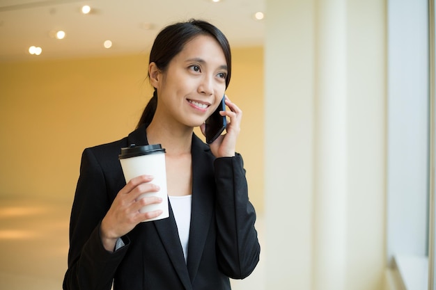 Une femme d'affaires asiatique parle au téléphone portable et parle au téléphone portable