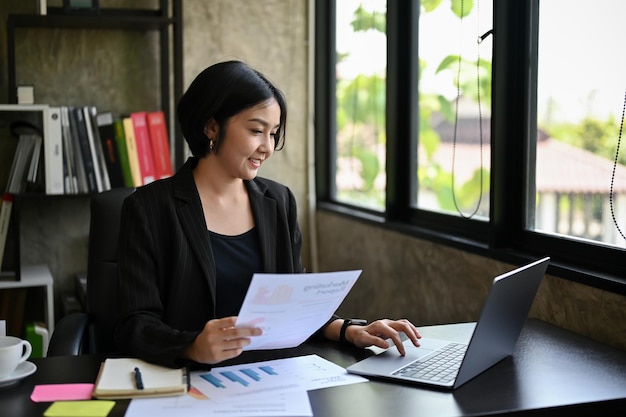 Une femme d'affaires asiatique professionnelle se concentre sur son travail en gérant son projet marketing