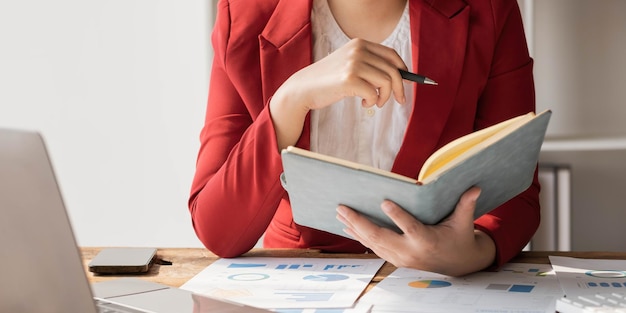 Femme d'affaires asiatique se réunissant au bureau en prenant des notes et en utilisant une tablette au bureau