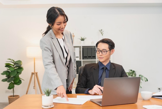 Femme d'affaires asiatique souriante montrant un rapport de document à son responsable lors d'une réunion au bureau