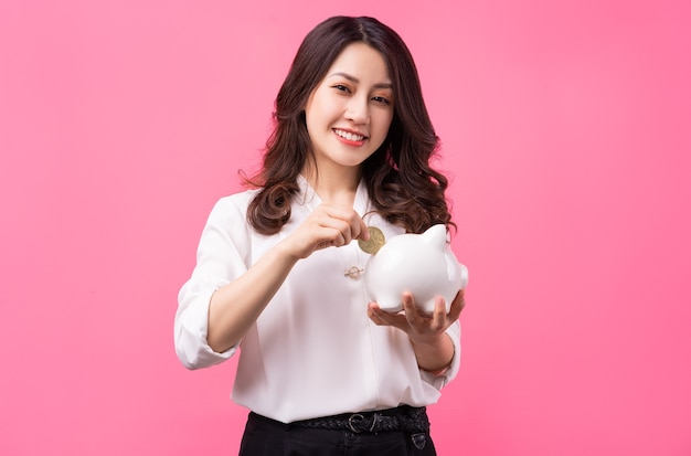 Femme d'affaires asiatique tenant piggy dans sa main, concept d'économie d'argent