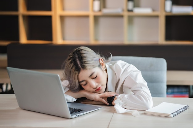 Femme d'affaires asiatique travail et sieste assise Femme d'affaires après avoir travaillé longtemps et somnolence sur la table et surmenage fatigué