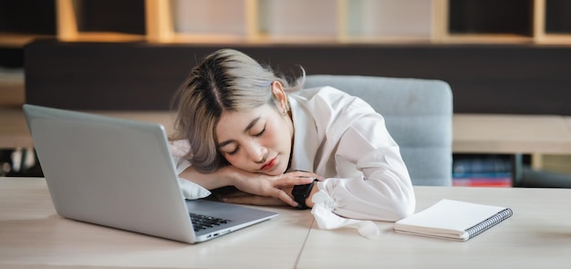 Femme d'affaires asiatique travail et sieste assise Femme d'affaires après avoir travaillé longtemps et somnolence sur la table et surmenage fatigué