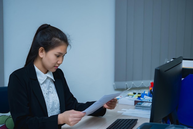 Femme d'affaires asiatique travaillant sur le bureau au bureauThaïlande travailleuse femme sourireBelle secrétaire a un beau sourireLady greffier des heures supplémentaires à l'entreprise