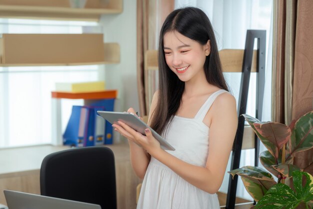 Photo une femme d'affaires asiatique travaillant dans un bureau à domicile sur la table avec un carnet d'ordinateur et une tasse de café