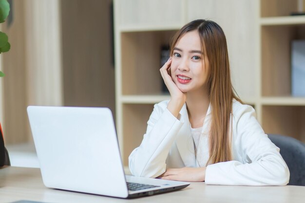 Femme d'affaires asiatique travaillant dans un espace de coworking à l'aide d'un ordinateur portable