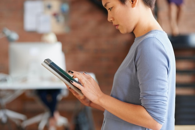 Femme d'affaires asiatique et travaillant sur une tablette au bureau pour la communication par e-mail de réseautage en ligne ou la planification d'une stratégie créative Entrepreneur startup tech stratergy et website ux design on ipad