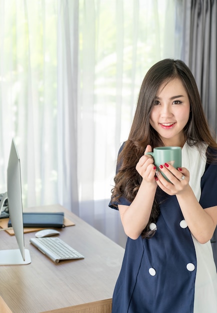 femme d&#39;affaires asiatiques heureux avec une tasse de café