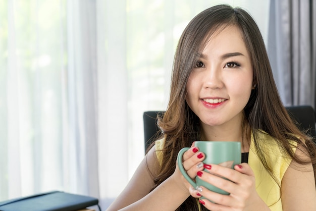 femme d&#39;affaires asiatiques heureux avec une tasse de café