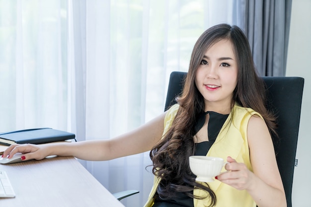 femme d&#39;affaires asiatiques heureux avec une tasse de café