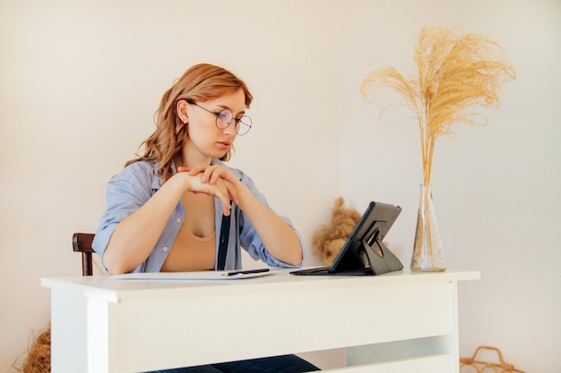 Photo une femme d'affaires assez jeune utilise une tablette numérique moderne au bureau travaillant à l'intérieur de la maison