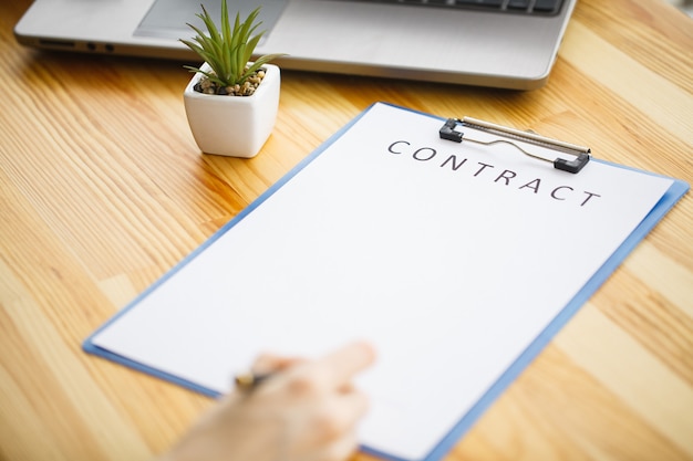 Femme d'affaires assis au bureau, signature d'un contrat avec peu profonde mettant l'accent sur la signature.